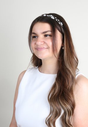 Abito bianco senza maniche, capelli castani mossi, fascia per capelli con perle, con una luce soffusa. Design semplice, sfondo chiaro, accessori discreti.