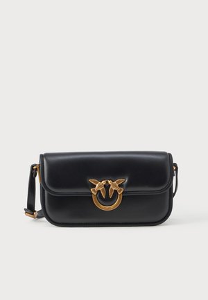 Borsa a tracolla in pelle nera con chiusura a cappuccio e hardware accentato in oro a forma di uccello su un anello circolare. Include una tracolla regolabile.