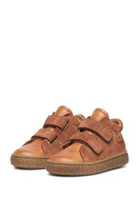 Hnědé semišové a kožené dětské boty se dvěma suchými zipy, zaoblenou špičkou a texturovanou gumovou podešví. Navrženo pro pohodlí a podporu.