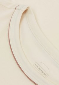 Beige stretch stof top met een ronde halslijn, voorzien van een subtiele donkere rand en een label met "intimissimi" aan de onderkant.