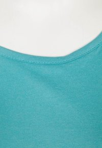 T-shirt in cotone turchese con scollo rotondo, texture a coste e finitura liscia. Design semplice senza motivi o accenti aggiuntivi.