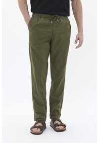 Olive green, lightweight pants with an elastic waistband and drawstring. Smooth texture, tapered design, two side pockets, paired with sandals.