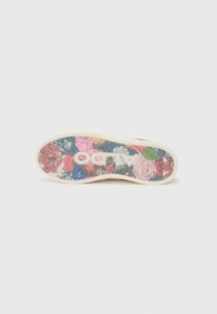 Shoe sole featuring a colorful floral pattern with pink, blue, and green accents on a translucent background; textured design and solid beige edge.