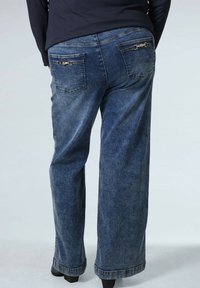 Donkerblauwe denim jeans met een relaxte pasvorm, voorzien van twee achterzakken met decoratieve hardware en een recht model.