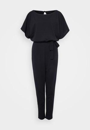 Schwarzer Jumpsuit mit kurzen Fledermausärmeln, einem Schlüsselloch-Rücken, tailliertem Design und schmal zulaufenden Beinen. Hergestellt aus glattem Stoff mit einer weichen Textur.