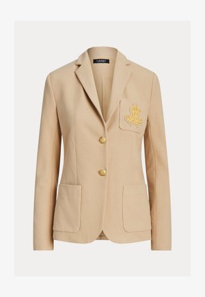 Μπεζ ραμμένο σακάκι με δύο μπροστινές τσέπες, χρυσή κεντητική στην αριστερή τσέπη του στήθους και δύο χρυσά κουμπιά στο κέντρο.