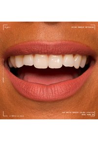 Nahaufnahme eines lächelnden Mundes mit einem glatten matten Lippenstift in Rosé und sichtbaren, gut ausgerichteten Zähnen, keine Make-up-Retusche.