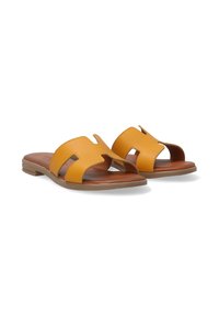 Gule lædersandaler med slidser og brune indlægssåler. Flad sål med en let tekstur og et minimalistisk design.
