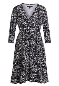 Mustavalkoinen kietaisumekko, jossa on V-pääntie ja pitkät hihat. Mekko on varustettu pilkullisella kuviolla, kerätyllä vyötäröllä ja levenevällä hameella.