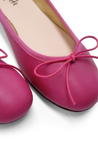 Ballerine in pelle fucsia con punta arrotondata, bordino elastico e dettaglio a fiocco sul davanti. Texture liscia con una leggera lucentezza.
