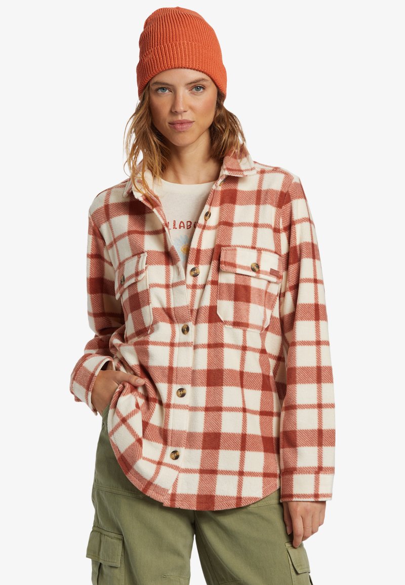 Red and white plaid flannel shirt with button closures, two front pockets, and a soft texture, paired with an orange knit beanie.