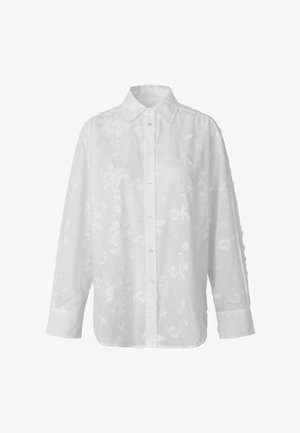 Camisa blanca de manga larga con botones, con patrón bordado floral y cuello puntiagudo.