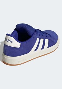 Baskets en suède bleu avec un design à trois bandes blanches, un col rembourré et une semelle en caoutchouc texturé blanc. Présente un logo sur le talon.