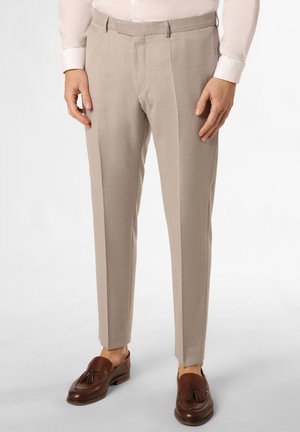 Braun-geschnittene Hose mit strukturiertem Muster, schlanker Schnitt und Gürtelschlaufen, kombiniert mit braunen Slippern. Mit Reißverschluss. 