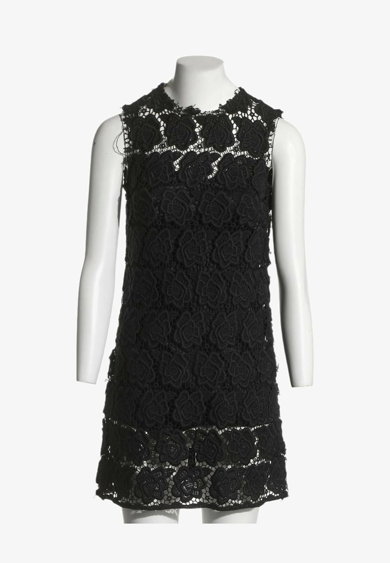 Robe noire sans manches en dentelle avec motif floral sur un buste de mannequin blanc sur fond blanc.
