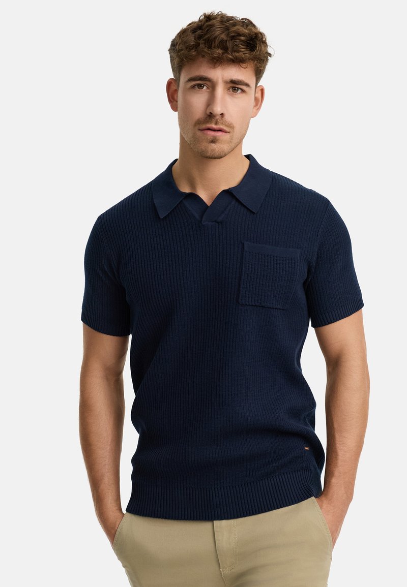 Sötétkék, kötött polo ing ribbed textúrával, rövid ujjal és mellzsebekkel. Klasszikus gallérral és testhez simuló fazonnal rendelkezik.