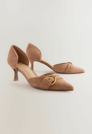 Kohdennetut varvasosat, vaaleanpunaiset mokkanahka korkokengät pienellä paksulla korolla. Koristeena on nauha, jossa on kultainen pyöreä solki ja kaksi lävistystä.