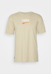 Beige katoenen t-shirt met korte mouwen, voorzien van een geborduurd wit "PUMA" logo en een oranje accent. Klassiek ronde halsontwerp.
