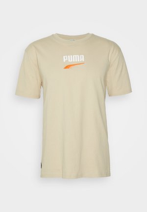 T-shirt in cotone beige con maniche corte, caratterizzato da un logo "PUMA" ricamato in bianco e un accento arancione. Design classico a girocollo.