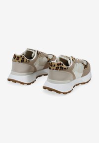 Zapatillas con una mezcla de materiales beige, con un diseño de estampado de leopardo en el talón, suela blanca y cordones. Apariencia texturizada y moderna.