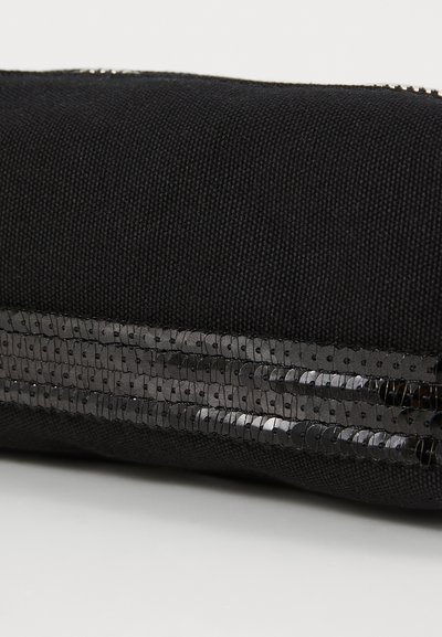 Pochette en tissu noir avec une rayure en sequins brillants pour plus de texture. La fermeture éclair est visible le long du bord supérieur.