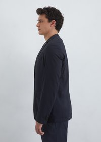 Navy blue blazer with a single button closure, notch lapels, and a side pocket, made of smooth fabric. Styled in a tailored fit.