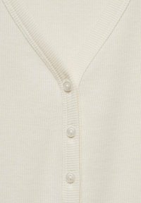 Ribbad krämfärgad cardigan med djup V-ringning, fem vita knappar och en mjuk textur med subtil lyster.