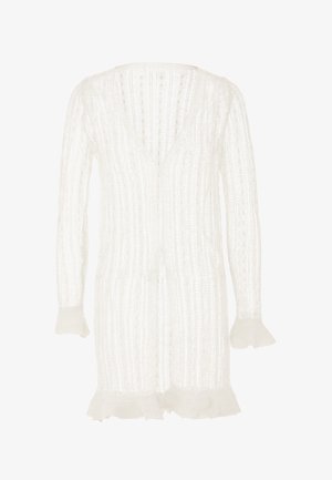 Cardigan bianco con scollo a V, silhouette allungata, texture a coste e maniche svasate con bordi frangiati. Design leggero e aperto.