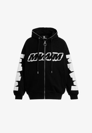 Sudadera con cremallera negra y capucha, con letras en bloque blancas que dicen "MVM" en la parte delantera y formas blancas alternadas en las mangas.