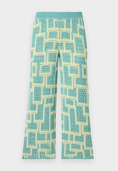 Vaļīgas bikses ar gaiši zilu un dzeltenu ģeometrisku rakstu, izgatavotas no teksturētas adītas auduma ar elastīgu jostasvietu.