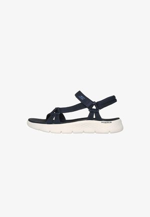 Dunkelblaue Stoffsandalen mit verstellbaren Riemen, einer gepolsterten weißen Sohle und einem strukturierten Fußbett; konzipiert für Komfort und Unterstützung.