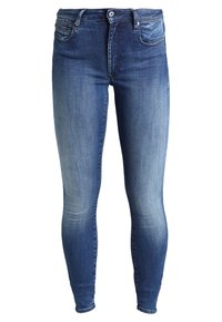 Jeans ajustados de color azul oscuro con efecto desgastado, diseño de cinco bolsillos y cierre de botón. Fabricados en tela de mezclilla con una textura suave.