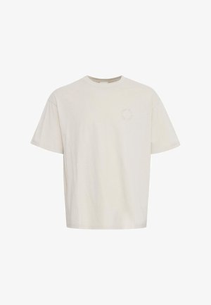 Kreemi värvi puuvillane t-särk lühikeste varrukatega, ümarate kaelustega ja väikese ümmarguse logoga vasakul rinnapiiril.