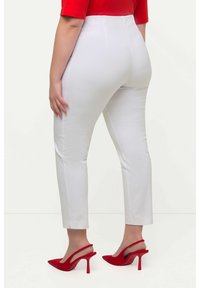 Witte op maat gemaakte broeken met een hoge taille, met een zachte textuur en een slim fit, gecombineerd met rode hoge hakken.
