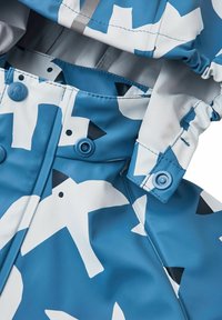 Vattentät jacka med blå bakgrund och vita fågelmönster. Inkluderar knappar och en justerbar huva med samlad detalj.