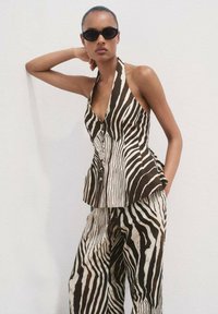 Top a fascia a righe marroni e crema con pantaloni a gamba larga. Progettato con bottoni e orlo svasato, caratterizzato da un tessuto leggero e morbido.