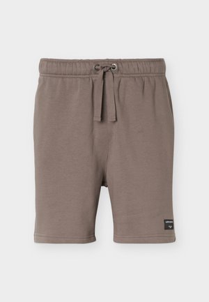 Brune shorts med elastisk midjebånd, snor og sidelommer, med en liten svart merkeetikett på nedre venstre ben.