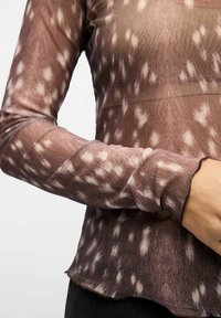 T-shirt à manches longues en tissu transparent à motifs, présentant des nuances de marron avec des accents blancs, design ajusté et ourlet festonné.