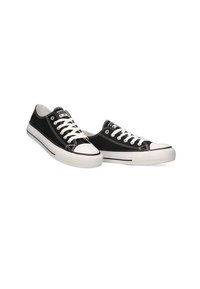Zapatillas de lona negras con suelas de goma blanca y punta blanca, con cordones y costuras blancas, diseño bajo para uso casual.