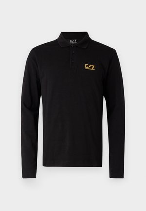 Čierna dlhá polokošeľa vyrobená z bavlny, s trojradovým zapínaním na gombíky a kontrastným žltým vyšitým logom na hrudi.