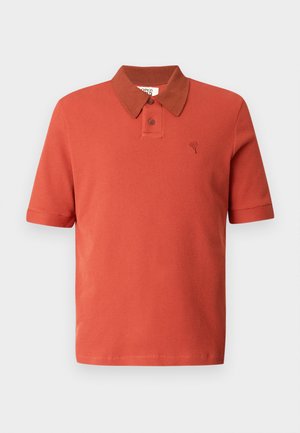 Polo majica s kratkimi rokavi v opečno rdeči barvi, teksturiranega blaga, z rjavim ovratnikom v kontrastu, dvema gumboma in izvezenim logotipom.