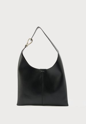 Melnas ādas plecu soma ar vienu siksnu un sudraba aizdares detaļu, ar mazu centrā novietotu logotipa birku uz vienveidīga fona.