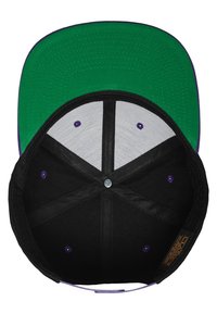 Cappello nero con visiera verde, con interni grigi e accenti viola sui fori di ventilazione e cuciture. Etichetta di marca visibile all'interno.