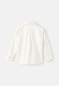 Bílá košile s dlouhým rukávem, límečkem, manžetami na knoflíky a hladkým povrchem. Žádné viditelné vzory ani kovové prvky, jednoduchý design.