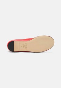 Scarpa rossa in pelle con finitura liscia, dotata di una suola color crema e un accento sul tallone nero. Contrassegnata dalla firma del designer e dalla taglia 37.