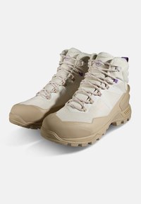 Beżowe wysokie buty z fakturowanej cholewki, kontrastującym jasnym dolnym materiałem, wzmocnionym czubkiem i wzorzystymi sznurowadłami z purpurowymi akcentami.