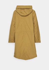 Długi, kapturowy płaszcz w kolorze musztardowej żółci, wykonany z lekkiej tkaniny. Posiada taliowanie i zatrzaski na mankietach rękawów.