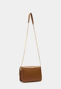 Hnědá kožená crossbody taška s texturovaným povrchem, má zlatý řetízek a zipový uzávěr, obdélníkový tvar se šitými okraji.
