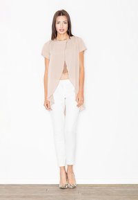 Beżowa, zwiewna bluzka z drapowaniem z przodu, zestawiona z białymi spodniami o zwężanym kroju. Dodatki to szpilki w wężowy wzór. Gładki materiał, lekka tekstura.