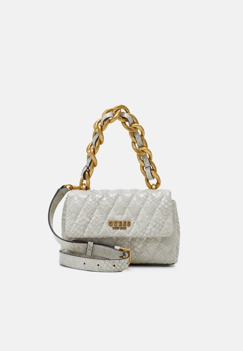 Sac à main matelassé gris clair Guess avec poignée chaîne dorée et bandoulière réglable assortie sur fond uni.